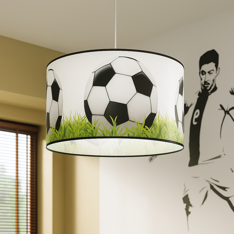 Kinderzimmer-Pendelleuchte mit Fußball-Motiv, bedruckt mit großen Schwarz-Weiß-Bällen auf grünem Rasen. Perfekte Deckenlampe für kleine Fußballfans und sportliche Einrichtungsideen im Jungenzimmer. Hintergrund mit Wandtattoo eines Fußballspielers unterstreicht das sportliche Raumdesign.